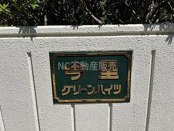 エントランスには落ち着いた色合いの館銘板が設置されています。視認性のあるデザインで建物の顔として印象的です。壁面は清潔感があり管理の行き届いた雰囲気が感じられます。