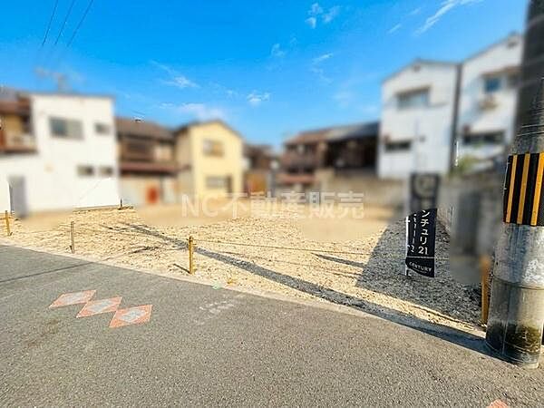 前面道路と現地の様子がよく分かる写真です。道路幅が広く車の出入りもしやすそうです。周囲には住宅が立ち並び落ち着いた雰囲気です。空も広がり開放感があります。整地された土地で使い勝手も良さそうです。