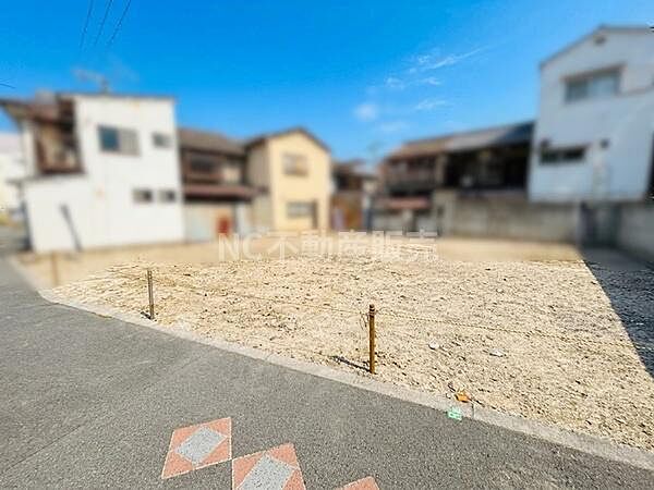 現地は開放感のある前面道路に面しています。道幅もしっかり確保されており車両の出入りがしやすい立地です。周辺には住宅が建ち並び落ち着いた雰囲気が広がっています。南側からの陽当たりも期待できます。