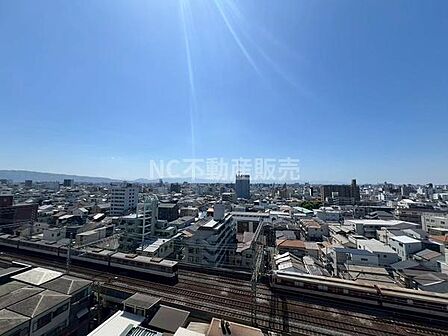 高層階からの眺望が広がり遠くまで見渡せる環境です。電車の線路や建物が一望できる爽快な景色が特徴です。晴天時は青空が広がり明るい雰囲気を感じられます。街の様子をしっかりと確認できるため開放感があります。