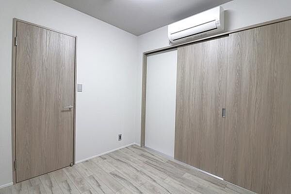 シンプルで明るい内装の洋室です。木目調の扉が空間にやさしい印象を与えます。クローゼットもあり収納面にも配慮されています。エアコンが設置されているため年間を通じて快適に過ごせます。