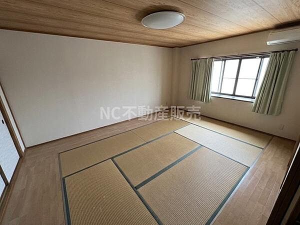 広々とした和室が特徴的です。落ち着いた色合いの畳が空間をすっきりと見せています。天井や壁もシンプルな仕上がりで様々な用途に対応しやすい雰囲気です。やわらかな自然光が入り明るさを感じられます。