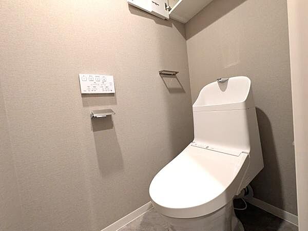快適にご利用いただける温水洗浄便座を採用し、清潔で心地よいトイレ空間を実現しています。上部にはトイレットペーパーや掃除用品をすっきり収納できる便利なトイレ収納付き。