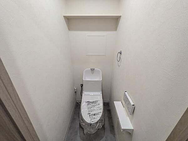 快適にご利用いただける温水洗浄便座を採用し、清潔で心地よいトイレ空間を実現しています。上部にはトイレットペーパーや掃除用品をすっきり収納できる便利なトイレ収納付き。