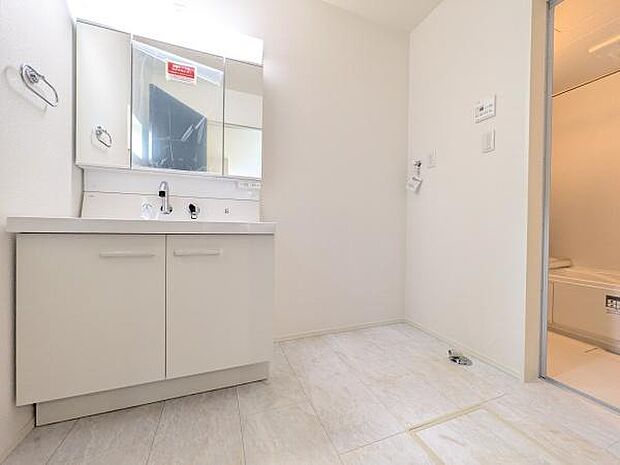 収納たくさんの三面鏡・窓もある洗面室。