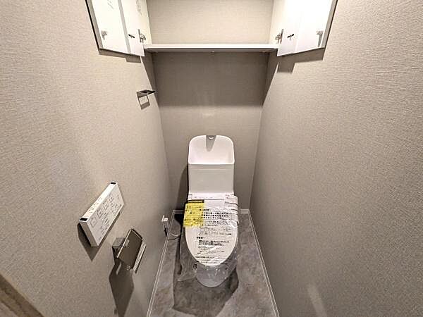 快適にご利用いただける温水洗浄便座を採用し、清潔で心地よいトイレ空間を実現しています。上部に棚もあり収納充実。