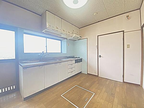 広々としたキッチンで収納スペースも充実しています。大きな窓から光が入り明るい印象です。使い勝手の良いシンクや作業スペースも整っています。清潔感のある内装が特徴です。大きな窓で採光良好、明るいキッチン。