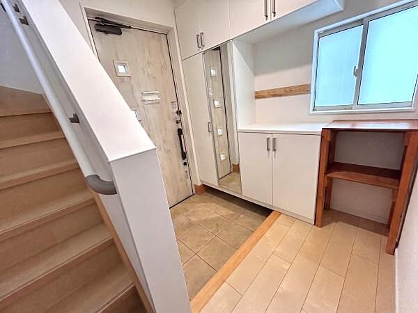 玄関は明るい色合いの床と収納が特徴ですっきりとした印象です。大きな鏡付きの収納があり外出前の身だしなみも整えやすいです。窓から自然光が入りやすいため玄関スペースが開放的に感じられます。