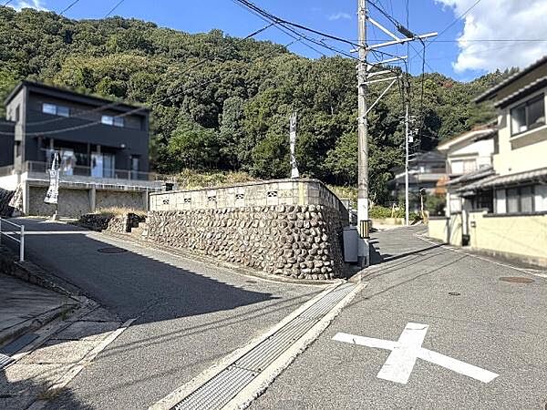 二方向に公道が接道する開放的な角地。現地はしっかりとした石積みの塀が印象的です。