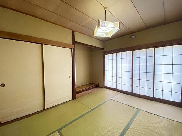 大きな障子が並び、柔らかな自然光をたっぷりと取り込む、明るく開放的な造りの1階約6.5帖の和室。