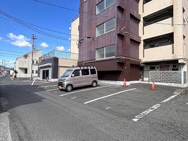 敷地内には駐車スペースが確保されており車の駐車にも便利です。建物前の駐車場は出入りがしやすい配置となっています。明るい空の下で開放感があります。コンクリート舗装が施されており清潔感があります。