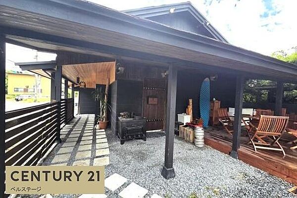 建物前には石畳風のアプローチと屋根付きのテラススペースがあります。木や石を活かした通路が印象的で、店舗の入り口としても雰囲気のある空間です！