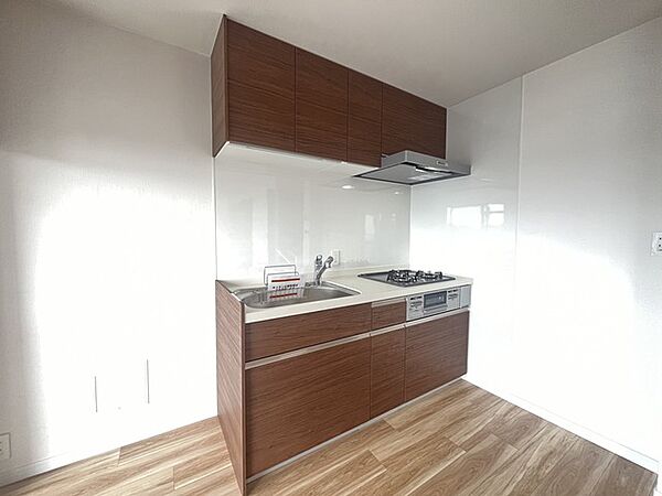 壁付のキッチンは上部に収納が作りやすいのがメリット。空間を有効活用したすっきりとしたデザイン。