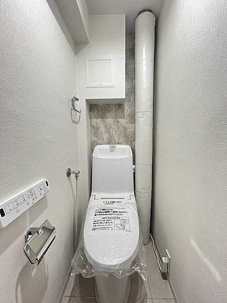 ウォシュレット機能付きのトイレ。収納もあり実用性も兼ね備えた造り。