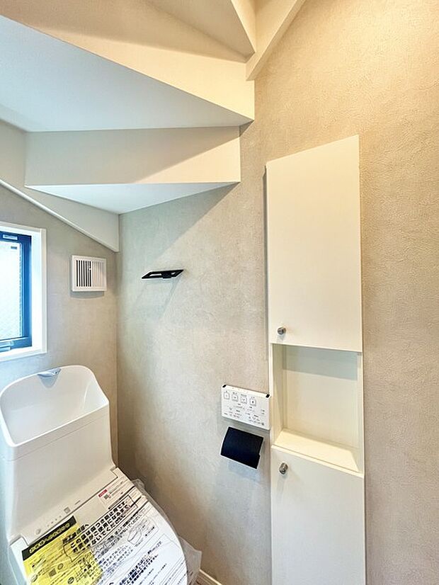 ウォシュレット機能付きのトイレ。換気のしやすい窓付きで、収納もあり実用性も兼ね備えた造り。