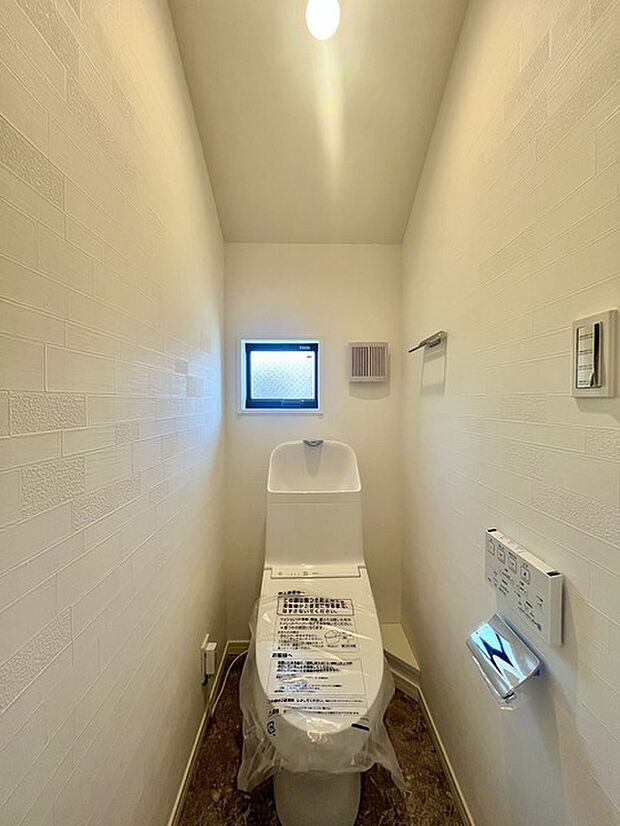 ウォシュレット機能付きのトイレ。換気のしやすい窓付きで、収納もあり実用性も兼ね備えた造り。