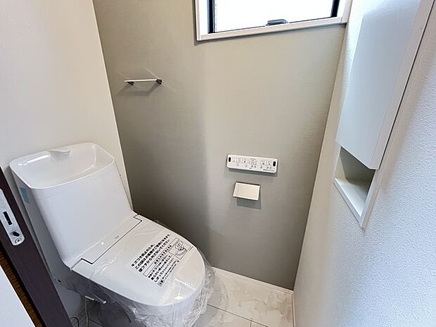 ウォシュレット機能付きのトイレ。収納もあり実用性も兼ね備えた造り。 