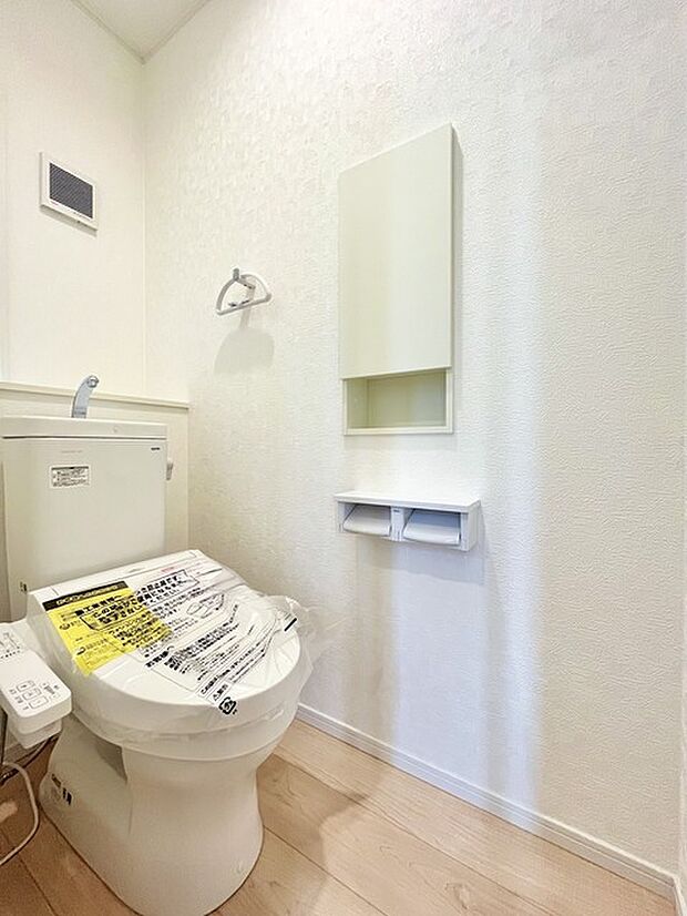 ウォシュレット機能付きのトイレ。収納もあり実用性も兼ね備えた造り。 