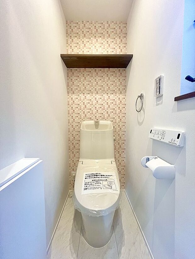 ウォシュレット機能付きのトイレ。収納もあり実用性も兼ね備えた造り。 