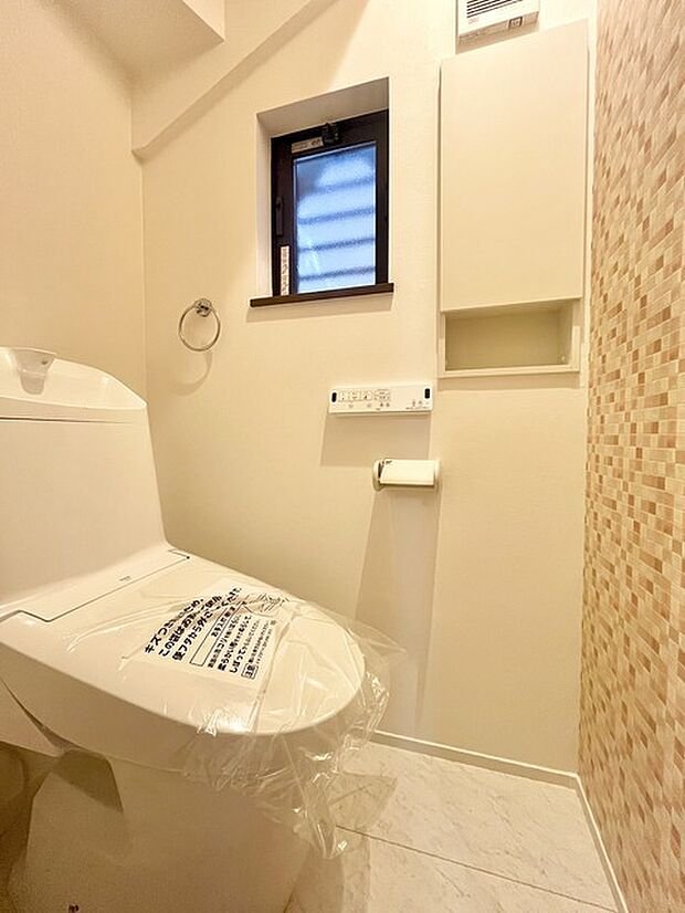 ウォシュレット機能付きのトイレ。換気のしやすい窓付きで、収納もあり実用性も兼ね備えた造り。 