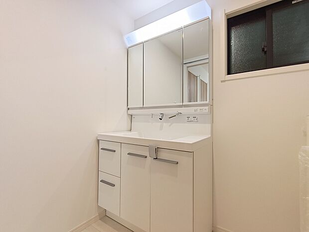 収納付きの洗面化粧台。 引き出し収納がある他、鏡の裏側も収納棚になっています。