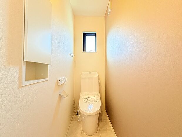 ウォシュレット機能付きのトイレ。換気のしやすい窓付きで、収納もあり実用性も兼ね備えた造り。