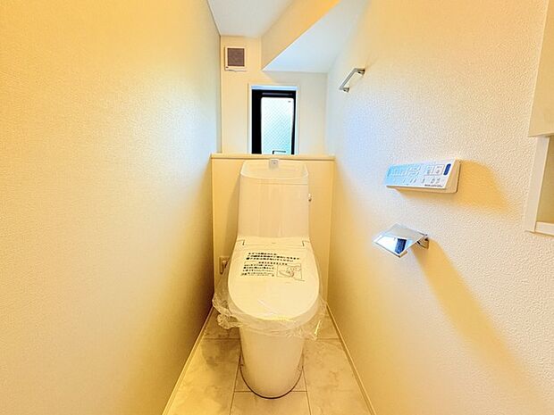 ウォシュレット機能付きのトイレ。換気のしやすい窓付きで、収納もあり実用性も兼ね備えた造り。