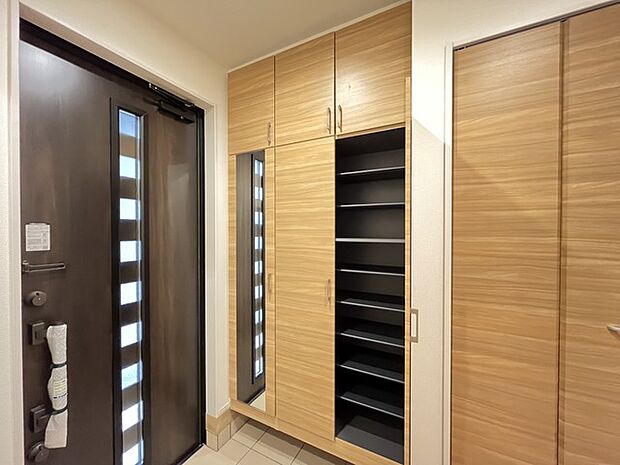 お宅の顔となる明るく開放的な玄関。ご家族皆様様の靴を収納できるスペースと全身鏡があり、お出掛け前に身だしなみチェックもできます。 