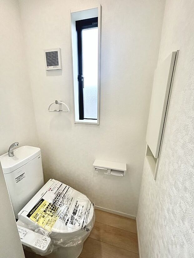 ウォシュレット機能付きのトイレ。収納もあり実用性も兼ね備えた造り。