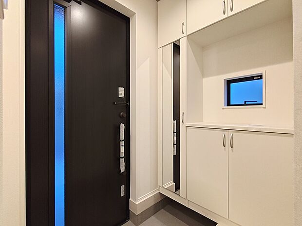 大きな靴棚を配した玄関ホール。 靴棚に設置した姿見鏡はお出かけ前の身だしなみチェックにお役立てください！