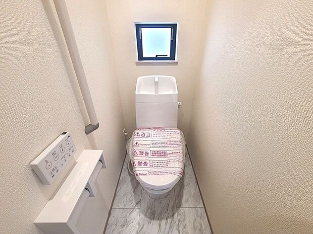 ウォシュレット機能付きのトイレ。換気のしやすい窓付きで、収納もあり実用性も兼ね備えた造り。 