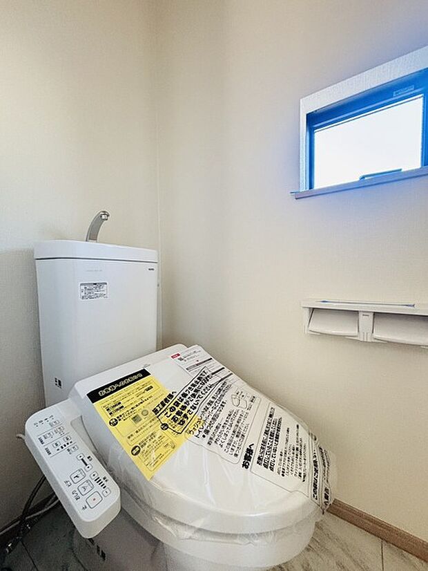 ウォシュレット機能付きのトイレ。換気のしやすい窓付きで、収納もあり実用性も兼ね備えた造り。 