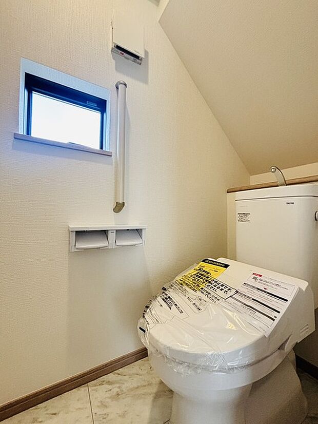 ウォシュレット機能付きのトイレ。換気のしやすい窓付きで、収納もあり実用性も兼ね備えた造り。 