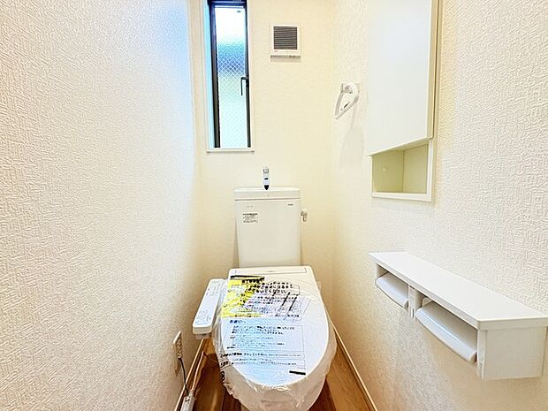 ウォシュレット機能付きのトイレ。換気のしやすい窓付きで、収納もあり実用性も兼ね備えた造り。
