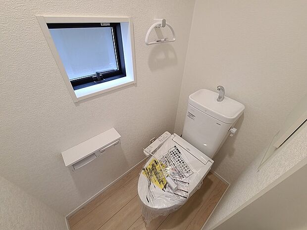 ウォシュレット機能付きのトイレ。換気のしやすい窓付きで、収納もあり実用性も兼ね備えた造り。