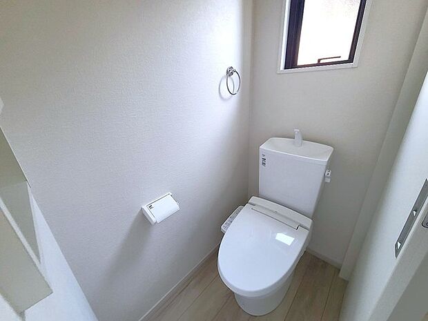 ウォシュレット機能付きのトイレ。換気のしやすい窓付きで、収納もあり実用性も兼ね備えた造り。