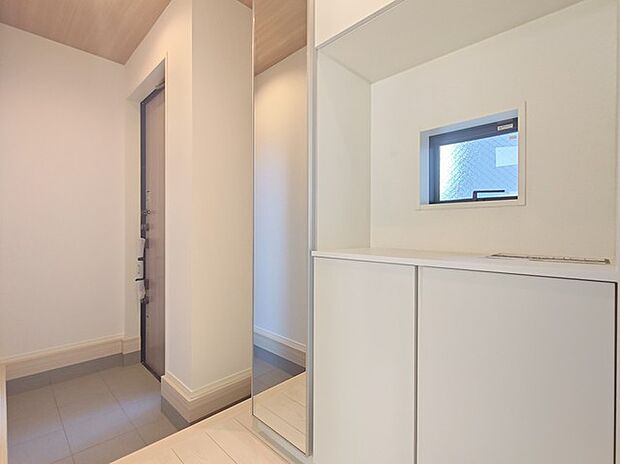 大きな靴棚を配した玄関ホール。靴棚に設置した姿見鏡はお出かけ前の身だしなみチェックにお役立てください！