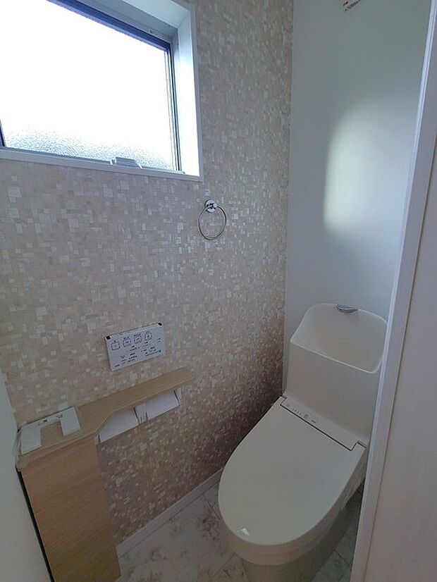 ウォシュレット機能付きのトイレ。換気のしやすい窓付きで、収納もあり実用性も兼ね備えた造り。 