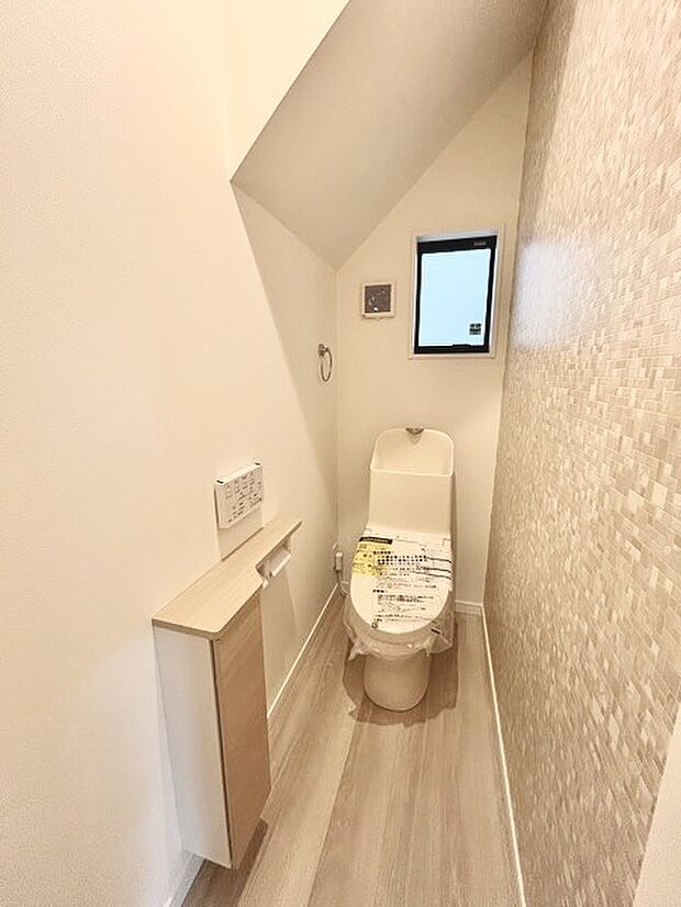 ウォシュレット機能付きのトイレ。換気のしやすい窓付きで、収納もあり実用性も兼ね備えた造り。 