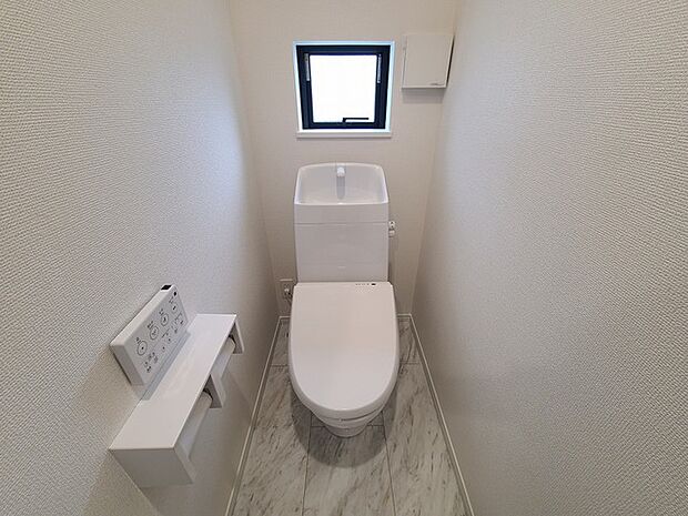 ウォシュレット機能付きのトイレ。換気のしやすい窓付きで、収納もあり実用性も兼ね備えた造り。