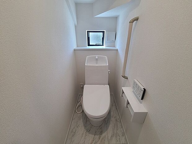 ウォシュレット機能付きのトイレ。換気のしやすい窓付きで、収納もあり実用性も兼ね備えた造り。
