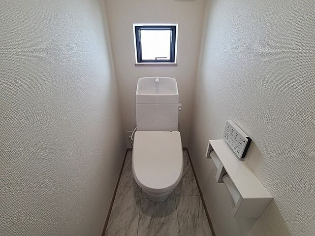 ウォシュレット機能付きのトイレ。換気のしやすい窓付きで、収納もあり実用性も兼ね備えた造り。