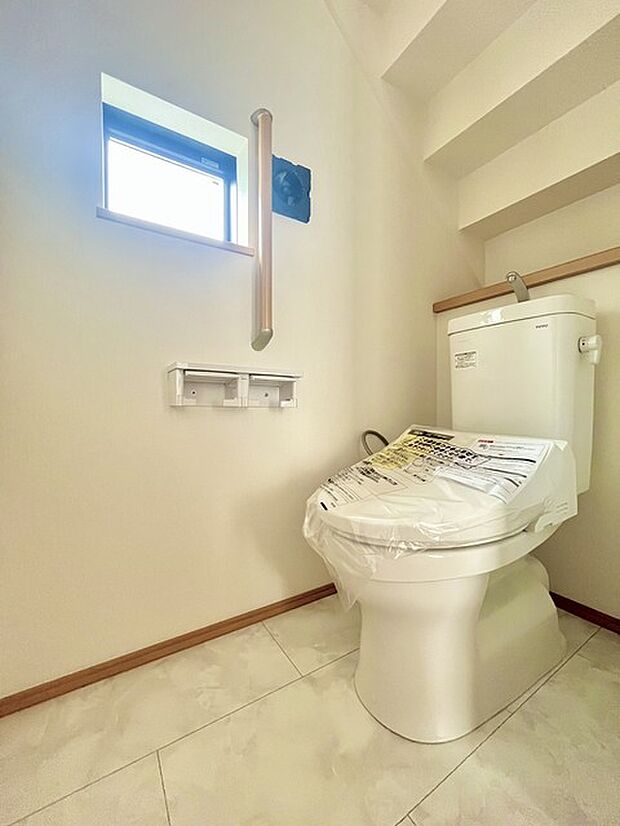ウォシュレット機能付きのトイレ。換気のしやすい窓付きで、収納もあり実用性も兼ね備えた造り。