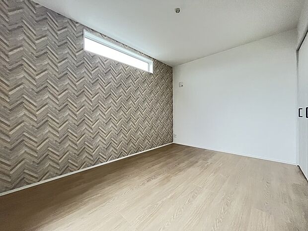 アクセントクロスを使用したオシャレな洋室。窓からそそぐ陽の光が眩しいベッドルームは、朝の目覚めが心地良く迎えられそうです。