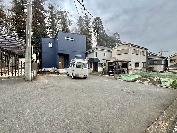 シンプルな外観が、周囲の緑と調和する穏やかな住まいです (10m)