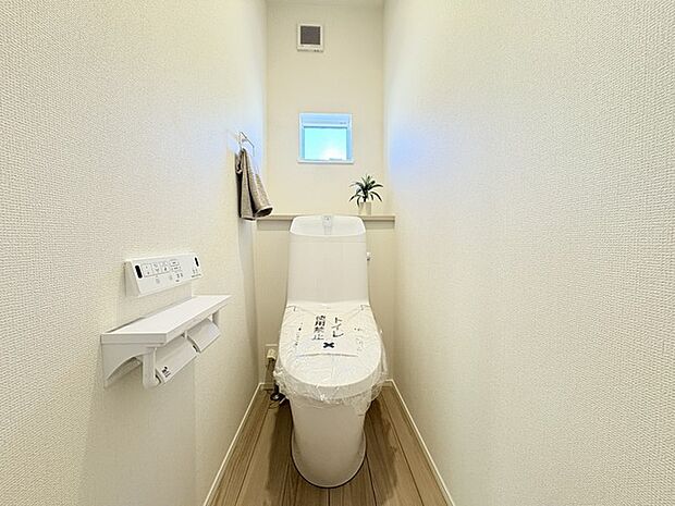 ウォシュレット機能付きのトイレ。換気のしやすい窓付きで、収納もあり実用性も兼ね備えた造り。