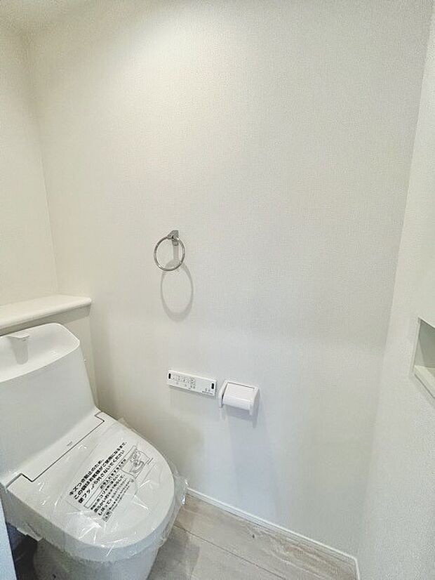 ウォシュレット機能付きのトイレ。収納もあり実用性も兼ね備えた造り。 