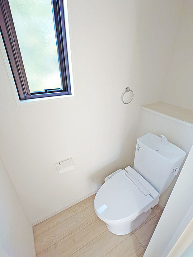 ウォシュレット機能付きのトイレ。換気のしやすい窓付きで、収納もあり実用性も兼ね備えた造り。