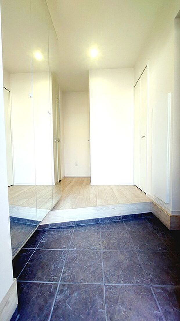 お宅の顔となる明るく開放的な玄関。ご家族皆様様の靴を収納できるスペースと全身鏡があり、お出掛け前に身だしなみチェックもできます。 