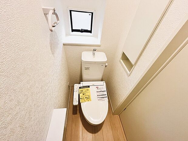 ウォシュレット機能付きのトイレ。換気のしやすい窓付きで、収納もあり実用性も兼ね備えた造り。